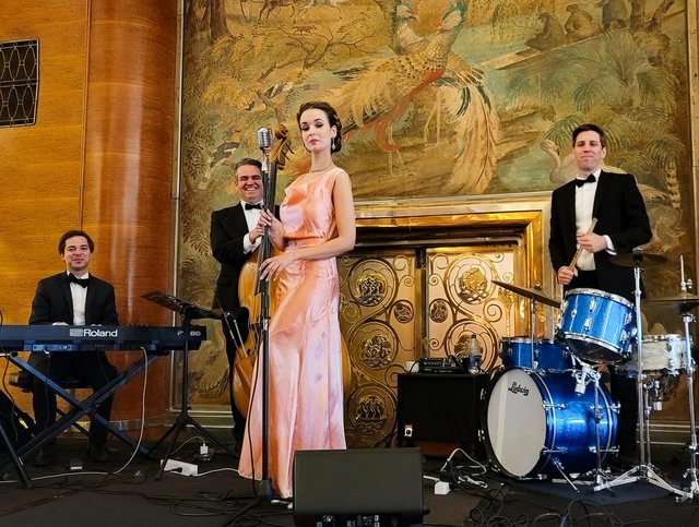 Blush satin gown and a black-tie trio by the gilded Art Deco fireplace of the Queen Mary Grand Salon